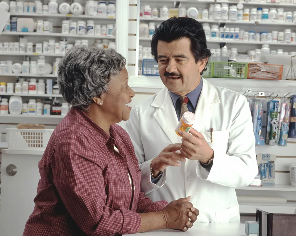A pharmacist explains a prescription to a customer